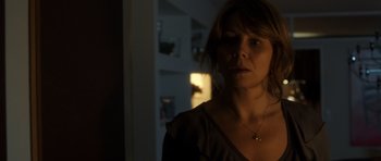 Movie still from “The Hunt” (2012), directed by Thomas Vinterberg – A person wearing a necklace in the dark; Close Up shot, Over the shoulder angle