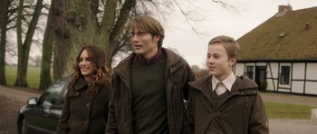 Movie still from “The Hunt” (2012), directed by Thomas Vinterberg – A man and two boys are walking in a park; Medium shot, Over the shoulder angle