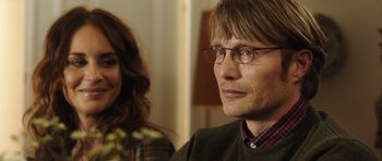 Movie still from “The Hunt” (2012), directed by Thomas Vinterberg – A person wearing glasses and a sweater; Close Up shot, Over the shoulder angle