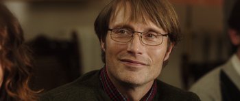 Movie still from “The Hunt” (2012), directed by Thomas Vinterberg – A person wearing glasses and a sweater; Close Up shot, Over the shoulder angle