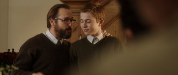 Movie still from “The Hunt” (2012), directed by Thomas Vinterberg – A man and a young boy are standing together; Close Up shot, Over the shoulder angle