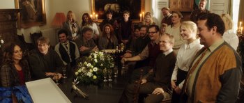 Movie still from “The Hunt” (2012), directed by Thomas Vinterberg – A group of people sitting around a dinner table; Wide shot, High angle