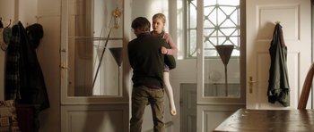 Movie still from “The Hunt” (2012), directed by Thomas Vinterberg – A man holding a little girl in his arms; Medium shot, Low angle