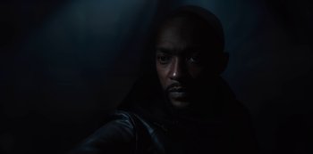 Movie still from “Altered Carbon” (2018), created by Laeta Kalogridis – A man in a black jacket is looking at the camera; Close Up shot, Low angle