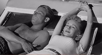 Movie still from “The Incredible Shrinking Man” (1957), directed by Jack Arnold – A man and a woman laying on the ground; Medium shot, High angle