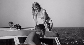 Movie still from “The Incredible Shrinking Man” (1957), directed by Jack Arnold – A woman standing on the back end of a boat next to a man; Medium shot, Low angle