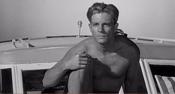 Movie still from “The Incredible Shrinking Man” (1957), directed by Jack Arnold – Black and white photograph of a man sitting on a boat; Medium shot, Low angle