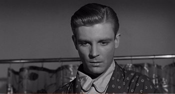 Movie still from “The Incredible Shrinking Man” (1957), directed by Jack Arnold – A young man with short hair and a bow tie; Close Up shot, Over the shoulder angle