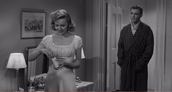 Movie still from “The Incredible Shrinking Man” (1957), directed by Jack Arnold – A man and a woman standing in front of a mirror; Medium shot, Over the shoulder angle