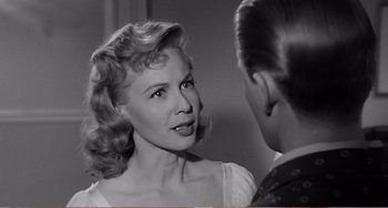 Movie still from “The Incredible Shrinking Man” (1957), directed by Jack Arnold – An old black and white photo of a woman talking to a young man; Close Up shot, Over the shoulder angle