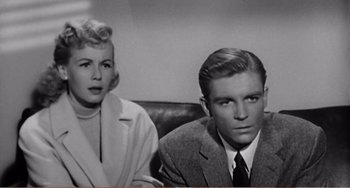 Movie still from “The Incredible Shrinking Man” (1957), directed by Jack Arnold – A man and a woman sitting next to each other in a room; Close Up shot, Low angle