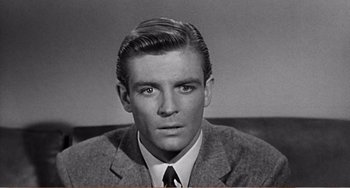 Movie still from “The Incredible Shrinking Man” (1957), directed by Jack Arnold – Black and white photograph of a man in a suit and tie; Close Up shot, Low angle