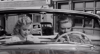 Movie still from “The Incredible Shrinking Man” (1957), directed by Jack Arnold – A man and a woman sitting in the back seat of a car; Medium shot, High angle