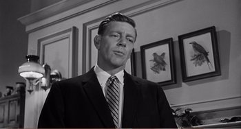 Movie still from “The Incredible Shrinking Man” (1957), directed by Jack Arnold – A man wearing a suit and tie in a room; Close Up shot, Low angle