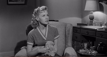 Movie still from “The Incredible Shrinking Man” (1957), directed by Jack Arnold – A black and white photo of a woman holding a cat; Medium shot, Low angle