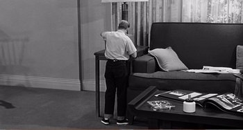 Movie still from “The Incredible Shrinking Man” (1957), directed by Jack Arnold – A man standing at a table in a living room; Wide shot, High angle