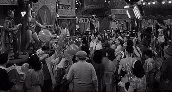 Movie still from “The Incredible Shrinking Man” (1957), directed by Jack Arnold – An old photo of a crowd of people at a carnival; Wide shot, High angle
