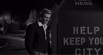 Movie still from “The Incredible Shrinking Man” (1957), directed by Jack Arnold – A black and white photo of a man standing next to a trash can; Medium shot, Low angle