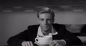 Movie still from “The Incredible Shrinking Man” (1957), directed by Jack Arnold – A man sitting at a table with a cup of coffee; Close Up shot, Over the shoulder angle