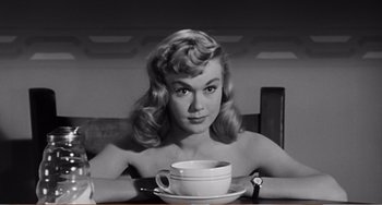 Movie still from “The Incredible Shrinking Man” (1957), directed by Jack Arnold – A black and white photo of a woman holding a coffee cup; Medium shot, High angle