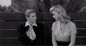 Movie still from “The Incredible Shrinking Man” (1957), directed by Jack Arnold – A man and a woman sitting next to each other on a bench; Medium shot, Over the shoulder angle