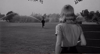Movie still from “The Incredible Shrinking Man” (1957), directed by Jack Arnold – A woman watches as a man runs through a field; Extreme Wide shot, Over the shoulder angle