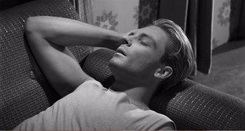 Movie still from “The Incredible Shrinking Man” (1957), directed by Jack Arnold – A man laying on a couch with his eyes closed; Close Up shot, High angle