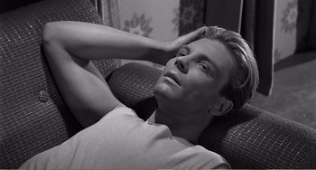 Movie still from “The Incredible Shrinking Man” (1957), directed by Jack Arnold – A man laying on a couch with his hands behind his head; Close Up shot, High angle