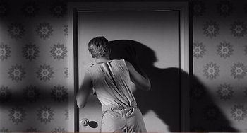 Movie still from “The Incredible Shrinking Man” (1957), directed by Jack Arnold – A woman standing in front of a mirror; Medium shot, Over the shoulder angle