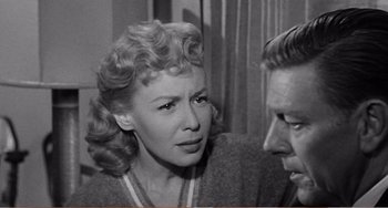 Movie still from “The Incredible Shrinking Man” (1957), directed by Jack Arnold – An old photo of a woman and a man talking to each other; Close Up shot, Over the shoulder angle