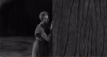 Movie still from “The Incredible Shrinking Man” (1957), directed by Jack Arnold – A woman standing next to a tree trunk; Medium shot, High angle