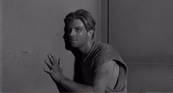 Movie still from “The Incredible Shrinking Man” (1957), directed by Jack Arnold – Black and white photograph of a young man in a towel; Medium shot, Low angle