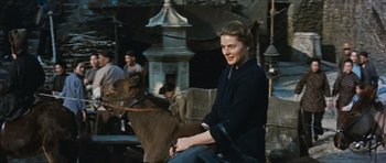 Movie still from “The Inn of the Sixth Happiness” (1958), directed by Mark Robson – A woman sitting on top of a brown horse; Medium shot, Over the shoulder angle