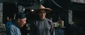 Movie still from “The Inn of the Sixth Happiness” (1958), directed by Mark Robson – A woman wearing a straw hat standing in front of an outdoor market; Medium shot, Over the shoulder angle