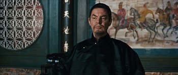Movie still from “The Inn of the Sixth Happiness” (1958), directed by Mark Robson – A man with a beard and mustache wearing a black shirt; Medium shot, Low angle