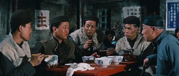 Movie still from “The Inn of the Sixth Happiness” (1958), directed by Mark Robson – A group of people sitting at a table eating food; Medium shot, Low angle