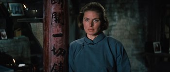 Movie still from “The Inn of the Sixth Happiness” (1958), directed by Mark Robson – A woman standing next to a pole in front of a building; Close Up shot, Low angle