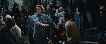 Movie still from “The Inn of the Sixth Happiness” (1958), directed by Mark Robson – A group of people gathered around a woman; Medium shot, Over the shoulder angle