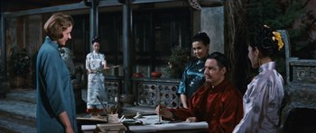 Movie still from “The Inn of the Sixth Happiness” (1958), directed by Mark Robson – A man sitting at a table in front of two women; Medium shot, Low angle