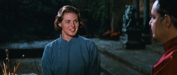 Movie still from “The Inn of the Sixth Happiness” (1958), directed by Mark Robson – A woman in a blue shirt smiling for the camera; Close Up shot, Over the shoulder angle