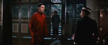 Movie still from “The Inn of the Sixth Happiness” (1958), directed by Mark Robson – A man in a red robe standing in front of another man; Medium shot, Over the shoulder angle