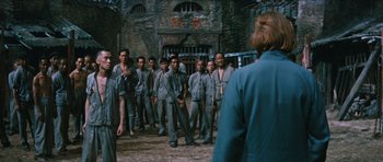 Movie still from “The Inn of the Sixth Happiness” (1958), directed by Mark Robson – A group of men standing next to each other in front of a building; Wide shot, Over the shoulder angle