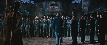 Movie still from “The Inn of the Sixth Happiness” (1958), directed by Mark Robson – A group of men standing in front of a group of people; Wide shot, High angle