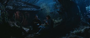 Movie still from “The Inn of the Sixth Happiness” (1958), directed by Mark Robson – A man and a woman sitting in the woods at night; Wide shot, High angle