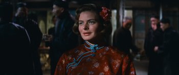 Movie still from “The Inn of the Sixth Happiness” (1958), directed by Mark Robson – A woman with a flower in her hair and wearing a red dress; Close Up shot, Over the shoulder angle