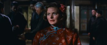 Movie still from “The Inn of the Sixth Happiness” (1958), directed by Mark Robson – A woman with a flower in her hair and a red dress; Close Up shot, Over the shoulder angle