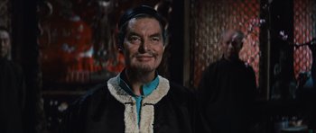 Movie still from “The Inn of the Sixth Happiness” (1958), directed by Mark Robson – An older man with a beard wearing a black robe; Medium shot, Over the shoulder angle