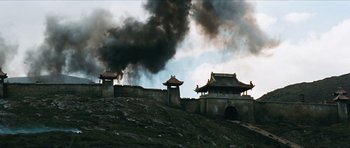 Movie still from “The Inn of the Sixth Happiness” (1958), directed by Mark Robson – Smoke billows out of a building on a hill; Extreme Wide shot, Low angle