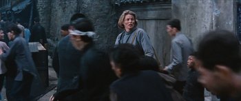 Movie still from “The Inn of the Sixth Happiness” (1958), directed by Mark Robson – An older woman walking down the street with a bag; Medium shot, Over the shoulder angle