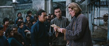 Movie still from “The Inn of the Sixth Happiness” (1958), directed by Mark Robson – A group of people standing next to each other on the street; Medium shot, Over the shoulder angle